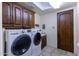 Bright laundry room with washer, dryer, and wood cabinets at 35931 N 82Nd Pl, Scottsdale, AZ 85266