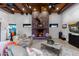Large living room with stone fireplace, exposed beams, and comfortable seating at 35931 N 82Nd Pl, Scottsdale, AZ 85266