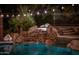 Serene waterfall feature adjacent to the pool at night at 35931 N 82Nd Pl, Scottsdale, AZ 85266