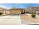 One-story house with a tan exterior, two-car garage, and desert landscaping at 1483 E Bradstock Way, San Tan Valley, AZ 85140