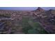 Sweeping aerial view of a lush golf course neighborhood nestled amid desert mountains at twilight at 3703 S Avenida De Angeles --, Gold Canyon, AZ 85118
