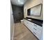 Stylish bathroom featuring a black countertop, white cabinets and long mirror with wood look flooring at 3703 S Avenida De Angeles --, Gold Canyon, AZ 85118