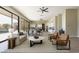 Open-concept living room with large windows, hardwood floors, and modern furnishings, seamlessly connecting to the dining area at 3703 S Avenida De Angeles --, Gold Canyon, AZ 85118