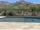 Inviting pool with mountain views, surrounded by a sleek black fence and beautiful desert landscaping at 3703 S Avenida De Angeles --, Gold Canyon, AZ 85118