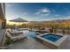Inviting backyard pool and spa featuring lounge chairs, outdoor kitchen, and scenic mountain views, perfect for entertaining at 3703 S Avenida De Angeles --, Gold Canyon, AZ 85118