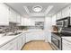 Updated kitchen with white cabinets, modern appliances, and mosaic backsplash at 6819 E Grandview Dr, Scottsdale, AZ 85254