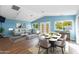 Open-concept living and dining area with vaulted ceilings, wood floors, and ample natural light from large windows at 6819 E Grandview Dr, Scottsdale, AZ 85254