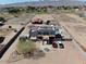 Aerial view of custom home, pool, multiple buildings and horse facilities in desert setting at 7214 N 183Rd Ave, Waddell, AZ 85355