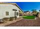 Artificial turf backyard with gravel accents and a view of a neighboring house at 9829 E Onza Ave, Mesa, AZ 85212