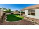 Landscaped backyard with artificial turf and a covered patio at 9829 E Onza Ave, Mesa, AZ 85212