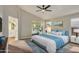 A serene main bedroom with a ceiling fan, blue accents, and a mirrored closet at 9829 E Onza Ave, Mesa, AZ 85212