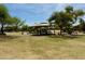 A lush green neighborhood park includes a covered playground, shade trees, and play equipment at 9829 E Onza Ave, Mesa, AZ 85212