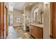 Bathroom with large mirror, stone vanity, and a soaking tub at 11334 E Troon Vista Dr, Scottsdale, AZ 85255