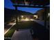 A backyard with a pergola-covered table, well lit landscaping and a fire pit for relaxing in this beautiful outdoor space at 11578 W Montansoro Ln, Peoria, AZ 85383