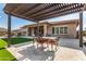 Pergola patio with table and chairs, overlooking backyard at 11578 W Montansoro Ln, Peoria, AZ 85383
