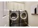 Laundry room with modern washer and dryer and upper cabinets at 17103 S 182Nd Ln, Goodyear, AZ 85338