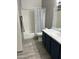 Bathroom with shower/tub combo, navy vanity, and gray floor tiles at 1941 S Pierpont Dr # 1090, Mesa, AZ 85206