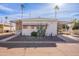 Front view of a white manufactured home with a carport and desert landscaping at 201 S Greenfield Rd # 142, Mesa, AZ 85206