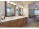 Double vanity bathroom with wood cabinets and large mirrors at 22555 W Antelope Trl, Buckeye, AZ 85326