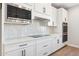 White kitchen with stainless steel appliances and white subway tile backsplash at 25893 W Running Deer Trl, Wittmann, AZ 85361