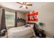 Cozy bedroom with a double bed, ceiling fan, and musical instruments at 29068 N 124Th Dr, Peoria, AZ 85383