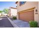 Attached garage with tan door and landscaping at 29068 N 124Th Dr, Peoria, AZ 85383