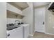 Convenient laundry room with washer, dryer, and extra shelving at 31271 N 133Rd Dr, Peoria, AZ 85383