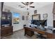 Home office with built-in wooden desk and large window at 31271 N 133Rd Dr, Peoria, AZ 85383