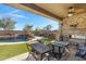 Covered patio with seating area and outdoor fireplace at 31271 N 133Rd Dr, Peoria, AZ 85383