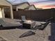 Relaxing backyard seating area with a modern fire pit and lounge chairs on a paved patio at 6807 W Winston Dr, Laveen, AZ 85339