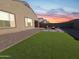 Lush backyard featuring artificial turf, a gravel border, and a patio with a fire pit at 6807 W Winston Dr, Laveen, AZ 85339
