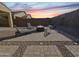 Cozy backyard with a fire pit surrounded by lounge chairs and a paved patio at dusk at 6807 W Winston Dr, Laveen, AZ 85339