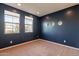 Roomy bedroom with dark blue walls and neutral carpeting at 6807 W Winston Dr, Laveen, AZ 85339