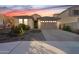 Charming single-story home with a tile roof and a two-car garage at dusk at 6807 W Winston Dr, Laveen, AZ 85339
