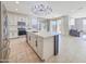 Open kitchen featuring a large island, white cabinets, stainless steel appliances, and seamless flow to the living area at 6807 W Winston Dr, Laveen, AZ 85339