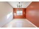 Room with orange accent wall and wood flooring at 6807 W Winston Dr, Laveen, AZ 85339