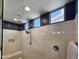 Bright, modern shower with a rainfall showerhead, white tiles, and clerestory windows at 6807 W Winston Dr, Laveen, AZ 85339