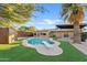 Inviting kidney-shaped pool with diving board, surrounded by artificial turf and a pergola at 7918 E Dale Ln, Scottsdale, AZ 85266