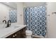 Clean bathroom with a modern vanity, shower, and stylish geometric patterned shower curtain at 7918 E Dale Ln, Scottsdale, AZ 85266