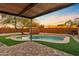 Relaxing pool area with a pergola, artificial turf and brick pavers at 7918 E Dale Ln, Scottsdale, AZ 85266