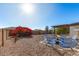 Charming backyard featuring a cozy seating area, desert landscaping and a blue patio set at 8039 E Madero Ave, Mesa, AZ 85209