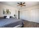Bedroom featuring closets, wood-look flooring, a ceiling fan, and a decorative painting at 8039 E Madero Ave, Mesa, AZ 85209