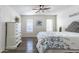 Brightly lit bedroom featuring two windows, wood-look flooring, and a decorative headboard at 8039 E Madero Ave, Mesa, AZ 85209
