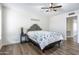 Bright bedroom featuring wood-look flooring, a tufted headboard, and a ceiling fan with a light fixture at 8039 E Madero Ave, Mesa, AZ 85209