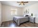 Bedroom features wood-look flooring, a ceiling fan, and a side table with decorative plant at 8039 E Madero Ave, Mesa, AZ 85209