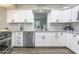 Well-lit kitchen featuring white cabinets, stainless steel dishwasher, and modern countertops at 8039 E Madero Ave, Mesa, AZ 85209