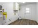 Bright laundry room features wood-look flooring, white cabinetry, and utility sink hookups at 8039 E Madero Ave, Mesa, AZ 85209
