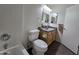 Cozy bathroom featuring a toilet, vanity, and shower-tub combo with white tiles and a decorative mirror at 8944 E Red Mountain Ln, Gold Canyon, AZ 85118