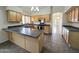Well-equipped kitchen with wood cabinets, a dark countertop island, and a breakfast bar, creating a functional cooking space at 8944 E Red Mountain Ln, Gold Canyon, AZ 85118