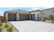 Modern three-car garage home with stone accents and desert landscaping at 9868 S Caballo Dr, Apache Junction, AZ 85120